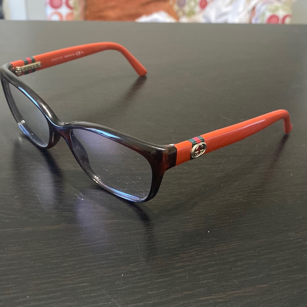 Gucci eye glass frames. Brown frame, burnt orange arms.Gucci logo on each side.